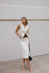 a lady wears a white suit vest with white midi denim skirt